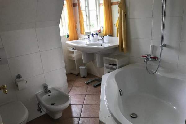 zweites Badezimmer im Obergeschoss mit Badewanne und Doppelwaschbecken